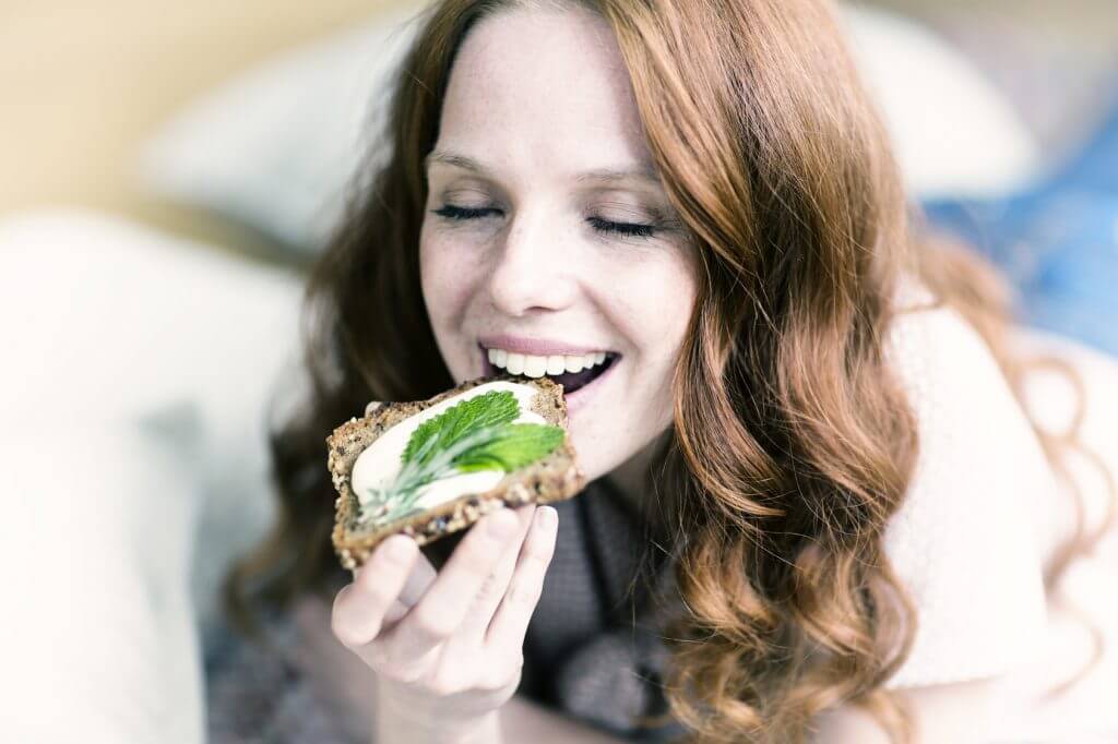 Chica practica oligoterapia comiendo una tostada saludable